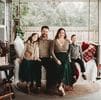 A family sitting on the porch of their home.