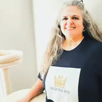 A woman with long hair and a crown on her shirt.