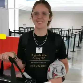 A woman in black shirt holding luggage at airport.